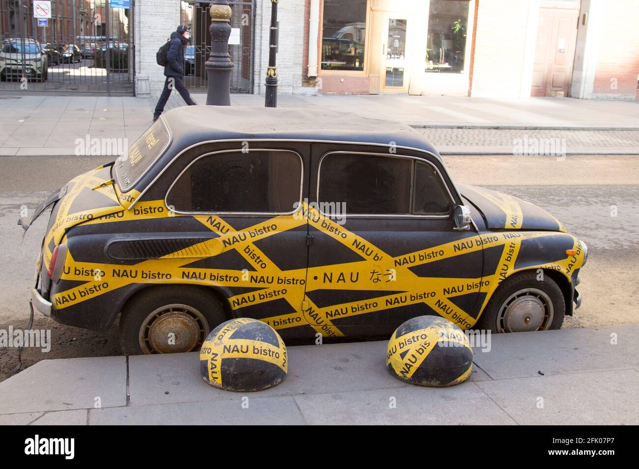 Divertente piccola auto coperta con pubblicità e nastri di segnale su Rubinstein Street a San Pietroburgo. Foto Stock