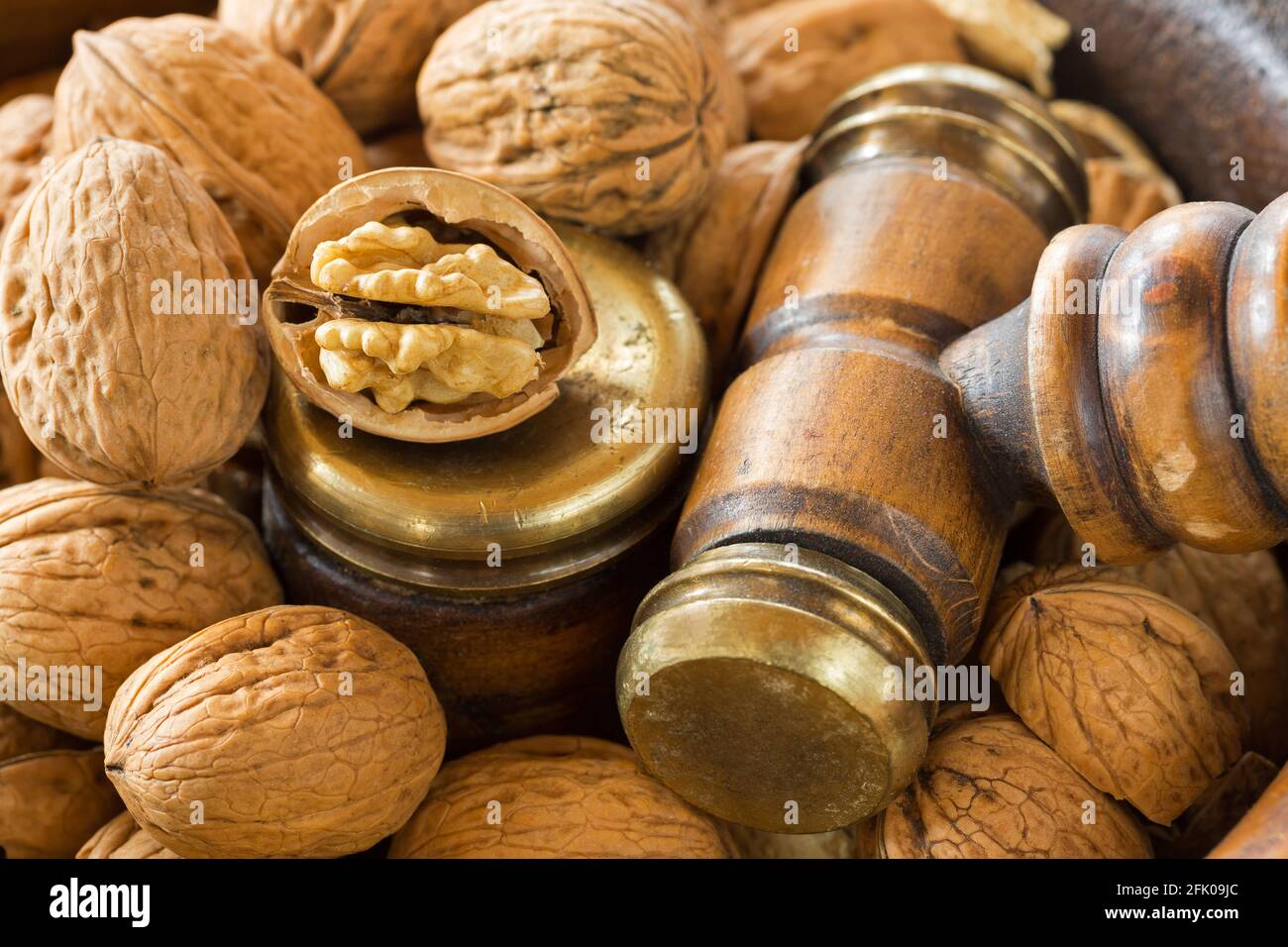 Noci aperte in ciotola di noce di legno vintage con Nutcracker di ottone martello a gavel Foto Stock