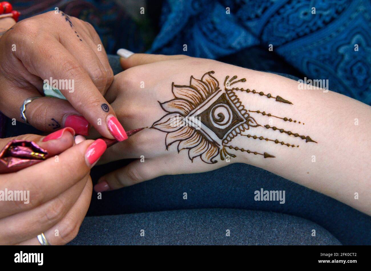 Donna artista mano applicando mehandi su una mano di ragazza con pennello. Festival di Yoga e Vedic Culture Vedalife-2017, Isola. 7 agosto 2017. Kiev, Ukra Foto Stock