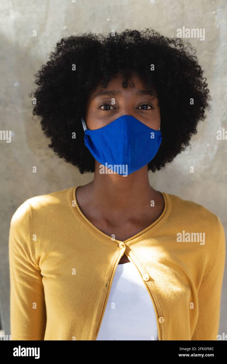 Ritratto di donna afroamericana che indossa maschera facciale guardando fotocamera Foto Stock