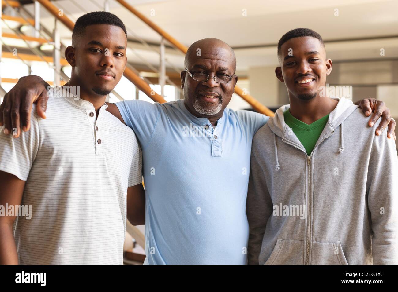Ritratto dell'anziano afroamericano e dei suoi due figli sorridendo mentre si sta a casa Foto Stock
