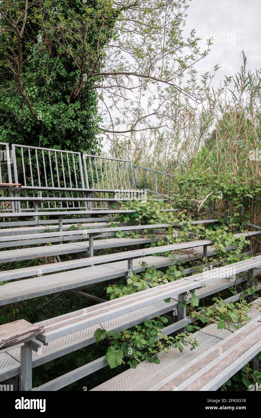 I bleachers abbandonati di fronte ad un campo da baseball in Toscana Italia Foto Stock