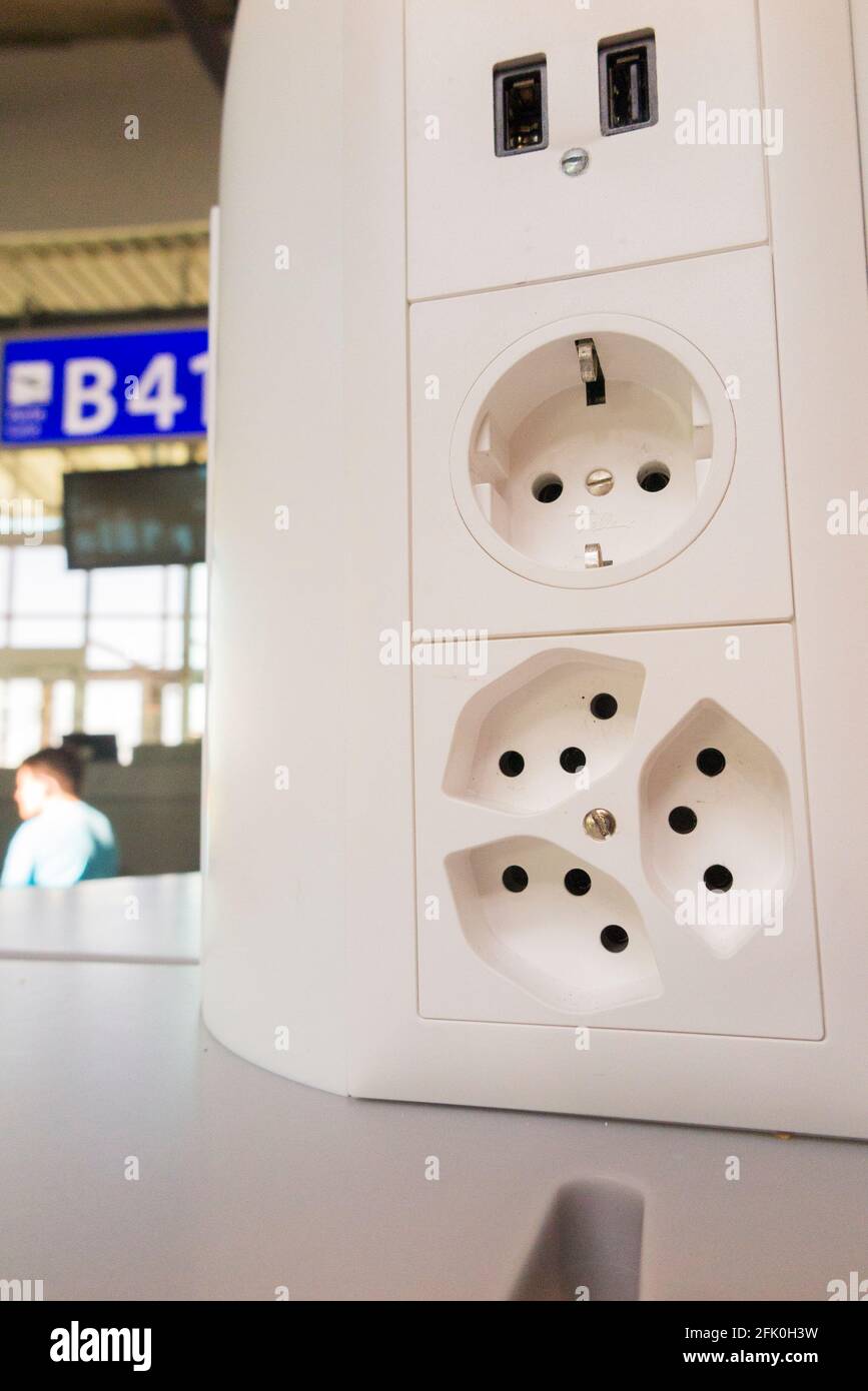Serie di prese elettriche di carica ( incl. Presa USB ) per caricare le  batterie elettriche nei dispositivi mobili dei passeggeri / passeggeri.  Aeroporto Cointrin di Ginevra, Svizzera Foto stock - Alamy