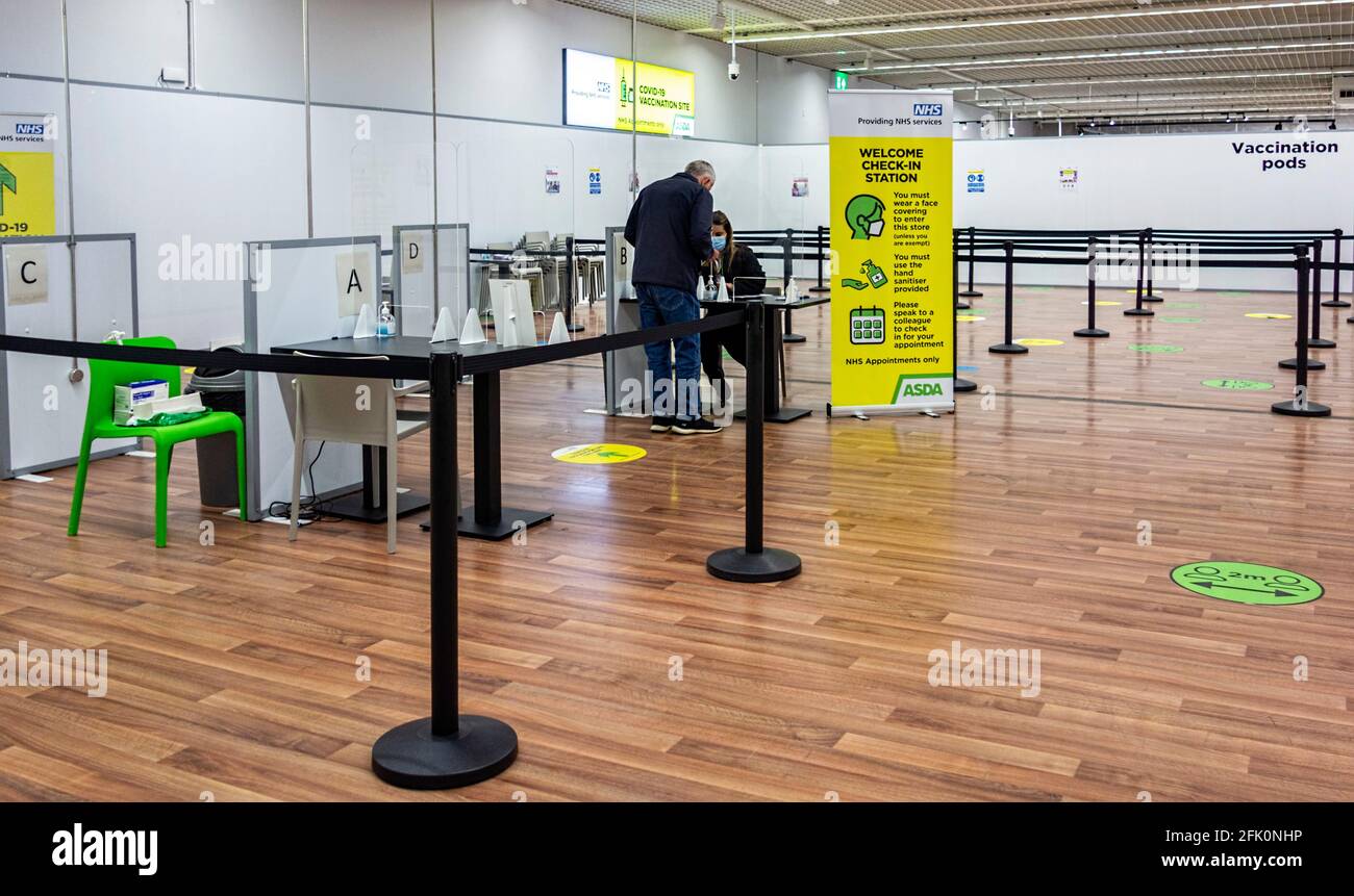 NHS Covid-19 vaccination Center at Asda, Watford Hertfordshire UK - Maschile Waiting at Covid-19 check in station Foto Stock