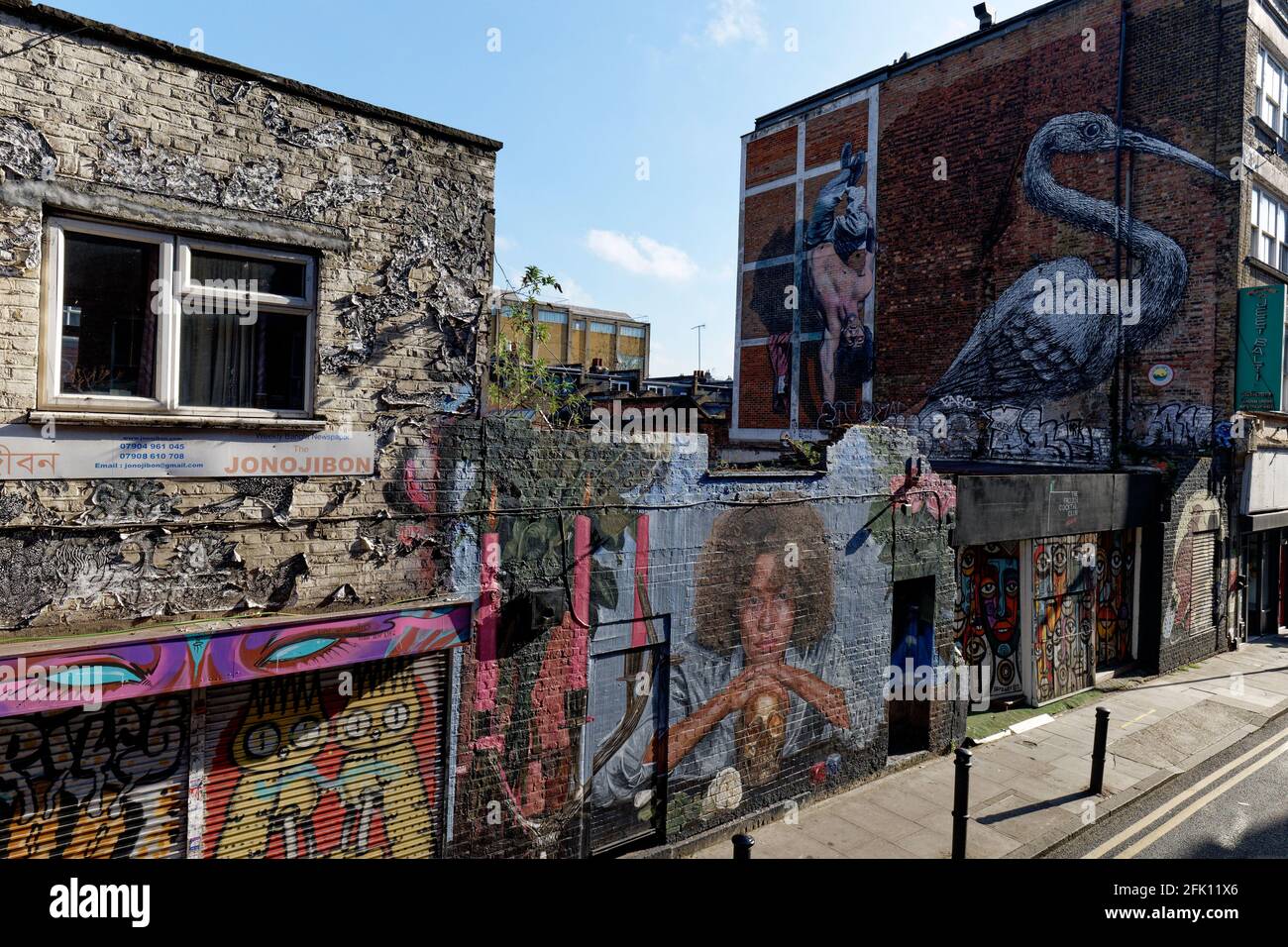 I colorati graffiti lungo Hanbury Street, fuori Brick Lane a Shoreditch, illuminano ciò che è una bella zona in discesa Foto Stock