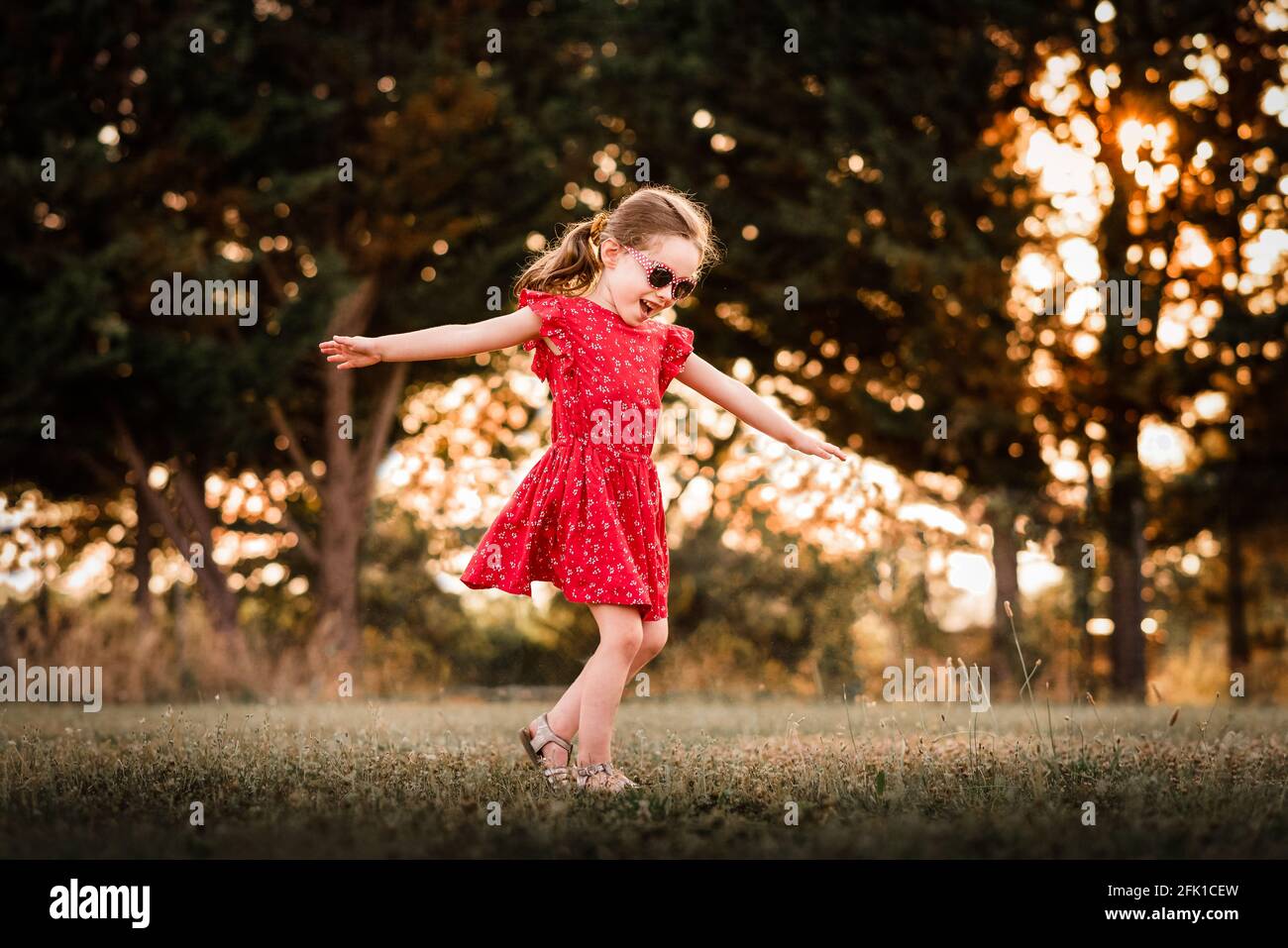 Girl twirls e gioca in campo erboso in estate a. Francia Foto Stock