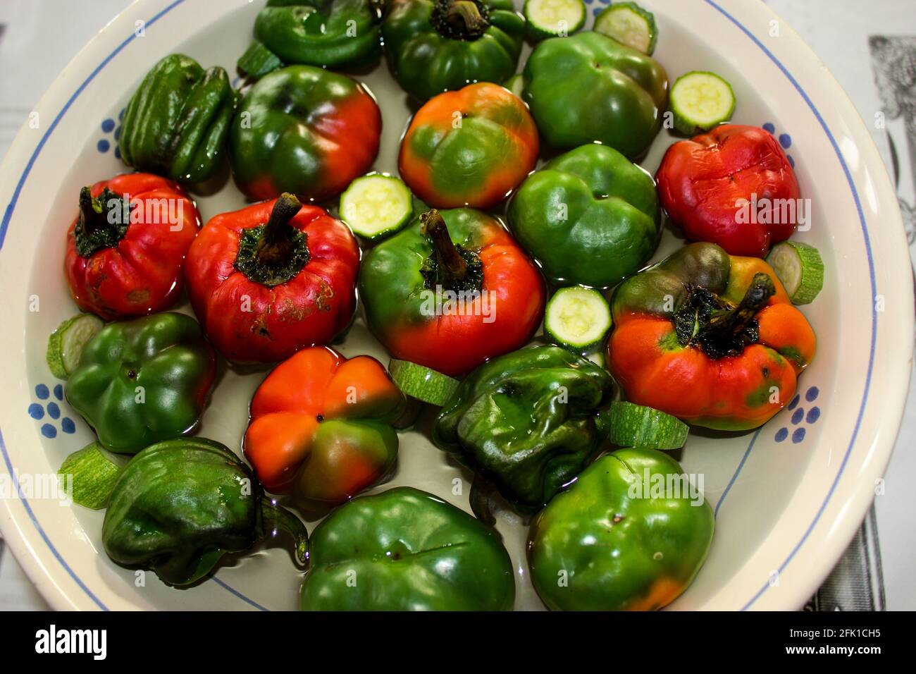 Ciotola con zucchine e tanti peperoni colorati, rossi, gialli, verdi, arancioni; pronti per essere preparati Foto Stock
