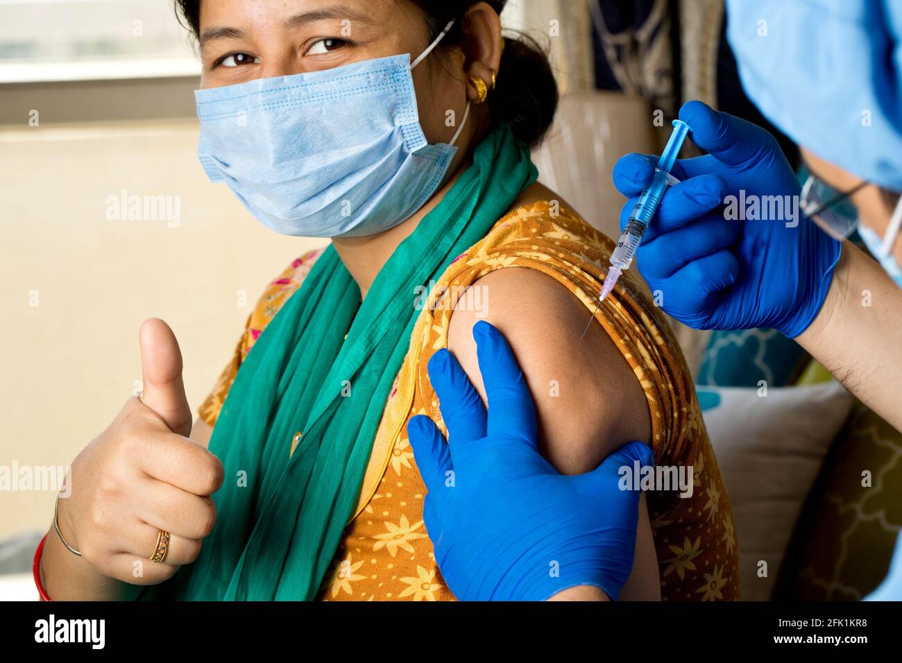 Medico che inietta il vaccino nel braccio del paziente Foto Stock