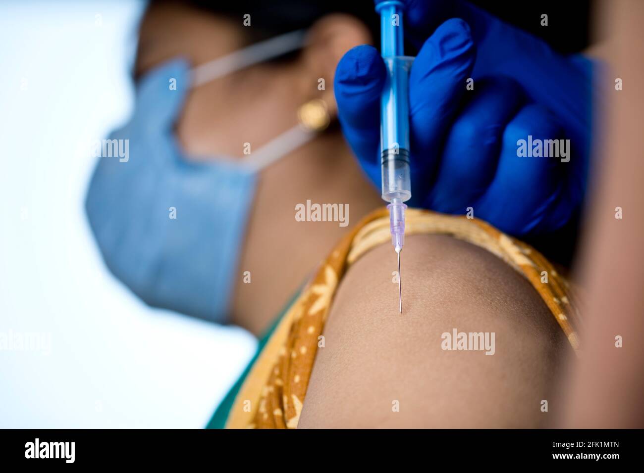 Medico che inietta il vaccino nel braccio del paziente Foto Stock