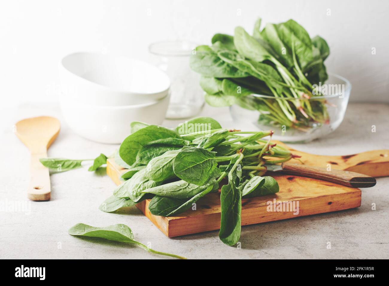 Foglie di spinaci verdi fresche su un tavolo da cucina. Foto Stock