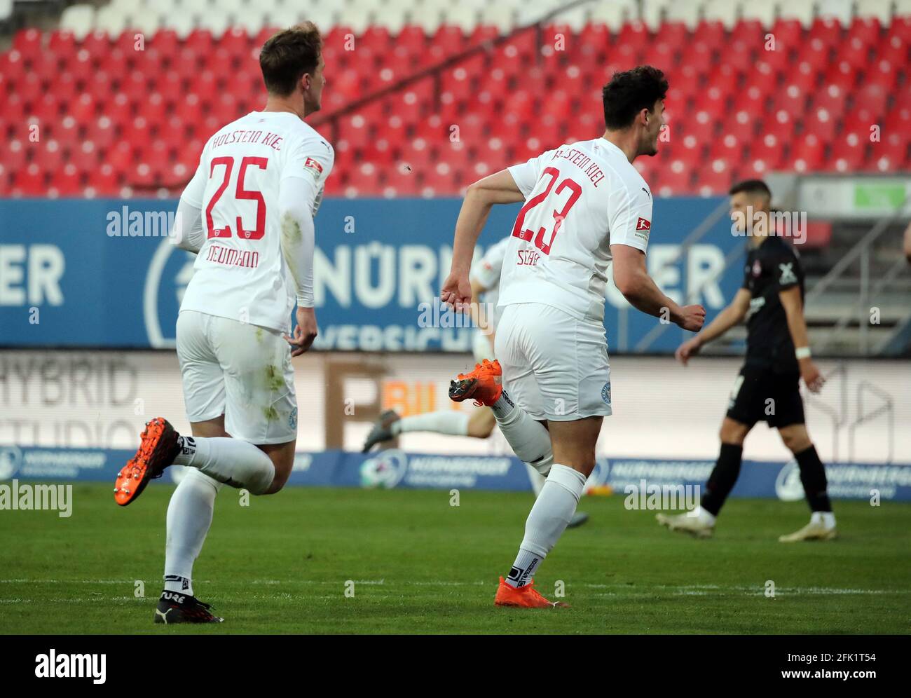 Norimberga, Germania. 27 Apr 2021. Calcio: 2. Bundesliga, 1. FC Nürnberg - Holstein Kiel, 29. giornata al Max-Morlock-Stadion. Janni Serra (r) di Kiel celebra il suo obiettivo di renderlo 1:1. NOTA IMPORTANTE: In conformità con le normative della DFL Deutsche Fußball Liga e della DFB Deutscher Fußball-Bund (Associazione tedesca del calcio), è vietato utilizzare o utilizzare fotografie scattate nello stadio e/o della partita sotto forma di sequenze di immagini e/o serie di foto di tipo video. Credit: Daniel Karmann/dpa/Alamy Live News Foto Stock