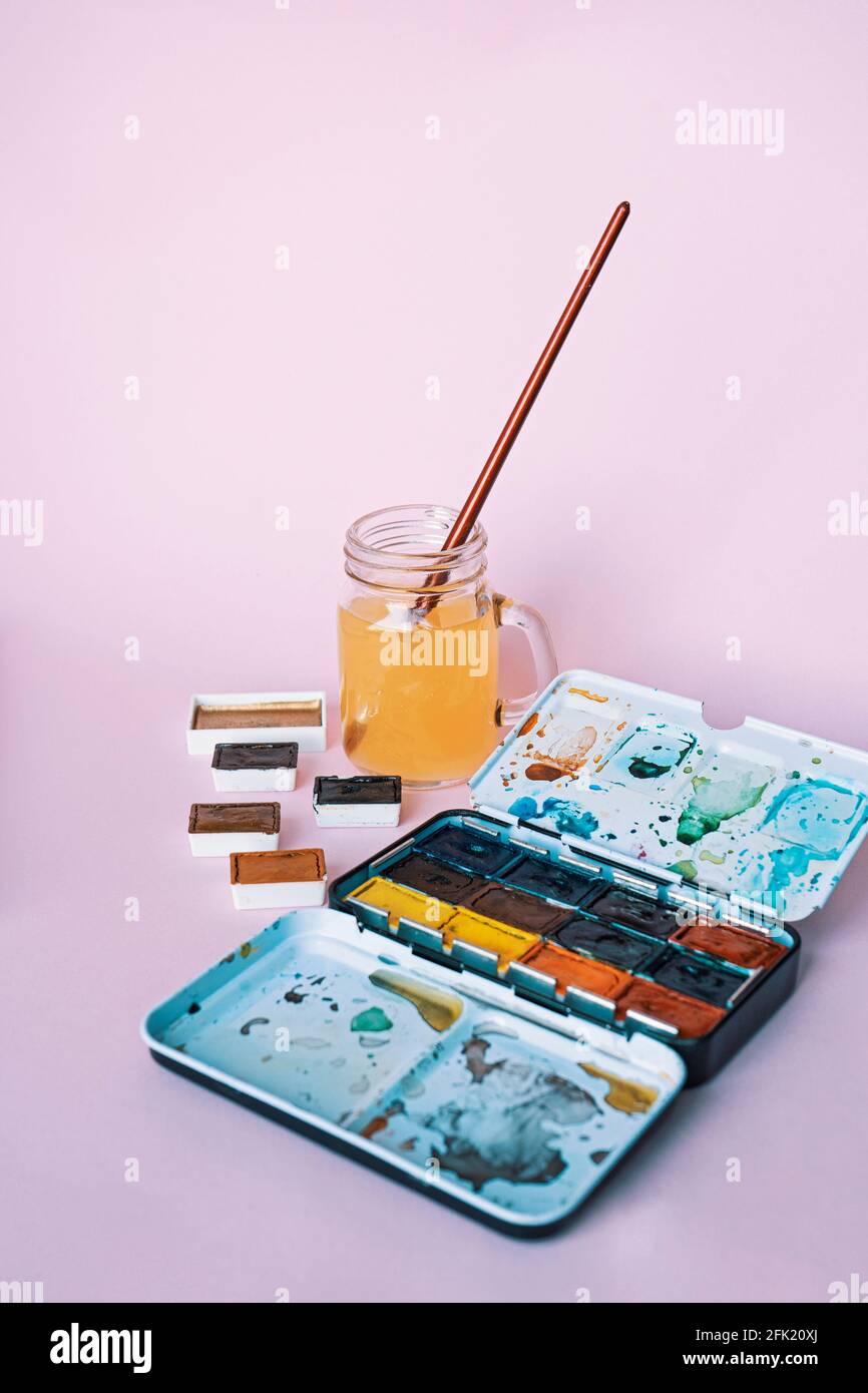 Luogo di lavoro dell'artista. L'arte fornisce pennelli, vernici, acquerelli e coppa d'acqua. Studio d'arte. Lezioni di disegno. Foto Stock