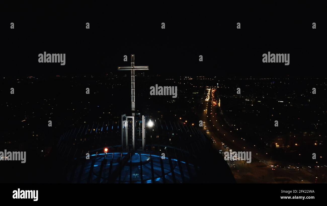 Varsavia, Polonia 12.01.2020 - Città di notte. Primo piano di croce all'edificio della Chiesa. La vita notturna di Varsavia. Strada trafficata con veicoli in funzione. Il cielo jet-black sullo sfondo. Foto Stock