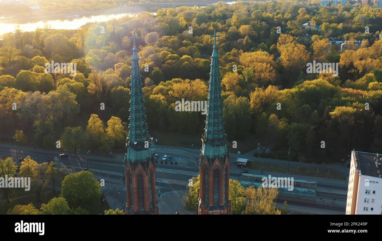 Varsavia, Polonia 12.01.2020 - Vista aerea delle torri gemelle della Cattedrale di San Michele Arcangelo e di San Florian il Martire. Luce del sole che colpisce i lussureggianti alberi verdi sullo sfondo. Lo scatto viene effettuato durante la sera. Foto Stock