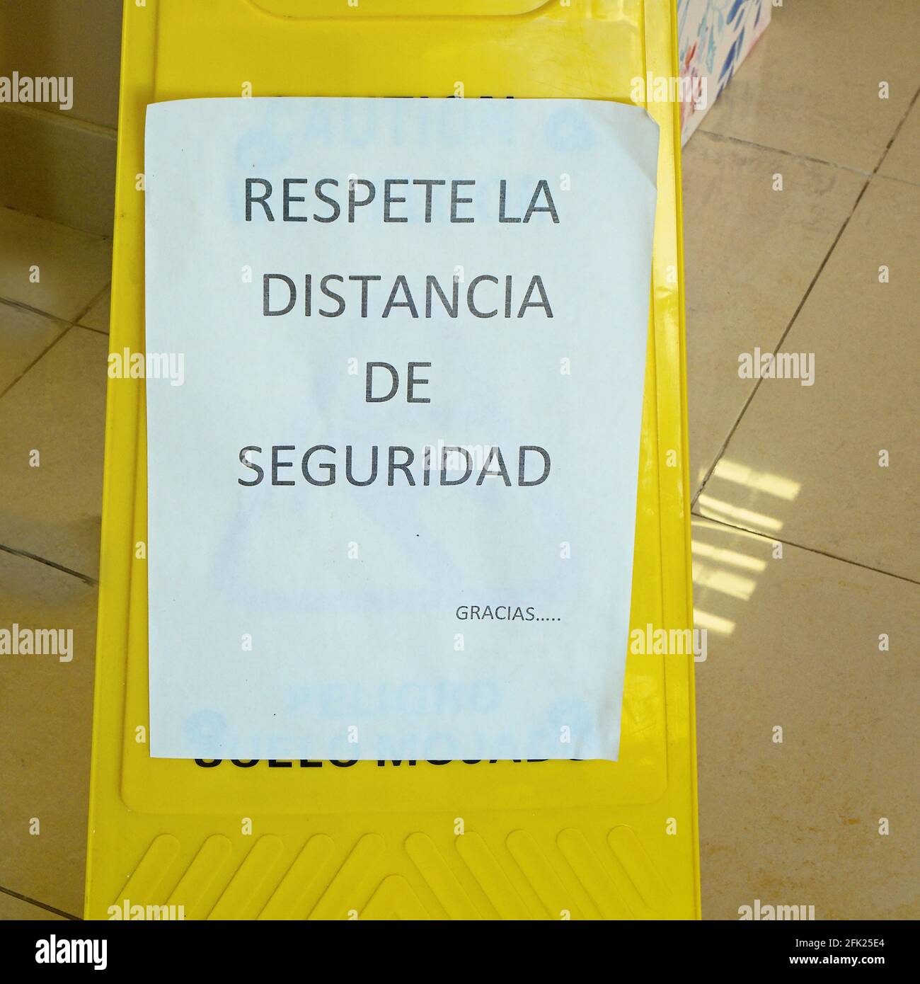 C'è un cartello di avvertimento in un negozio che recita 'Respeta la Distancia de Seguridad' in spagnolo. Rispettare la distanza di sicurezza nei tempi di Corona. Foto Stock