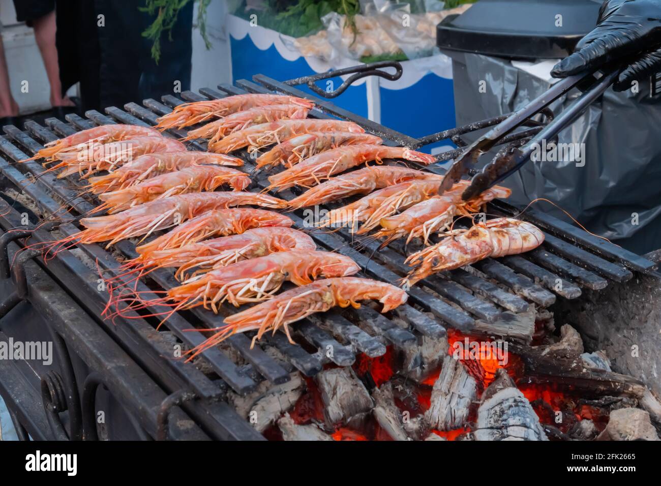 Chef che cucinano gamberi rossi di langoutine freschi, gamberi alla griglia a cibo locale estivo Foto Stock