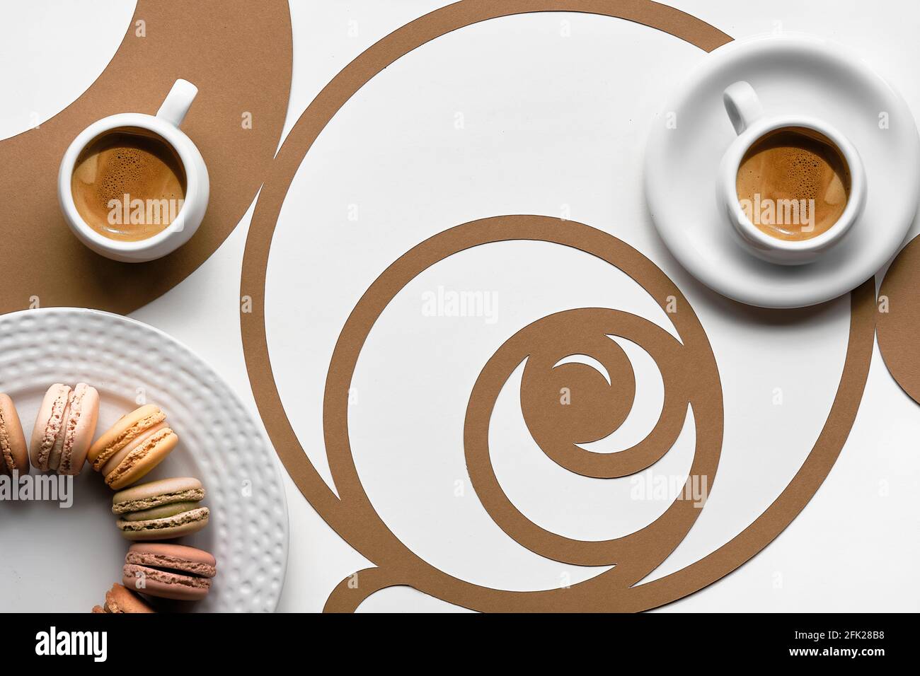 Tazze da caffè, macaron, cerchi di sequenza Fibonacci. Espresso, gustosa perfezione. Concetto di rapporto d'oro, arte della carta Vista dall'alto, disposizione piatta in due tonalità, bianco Foto Stock