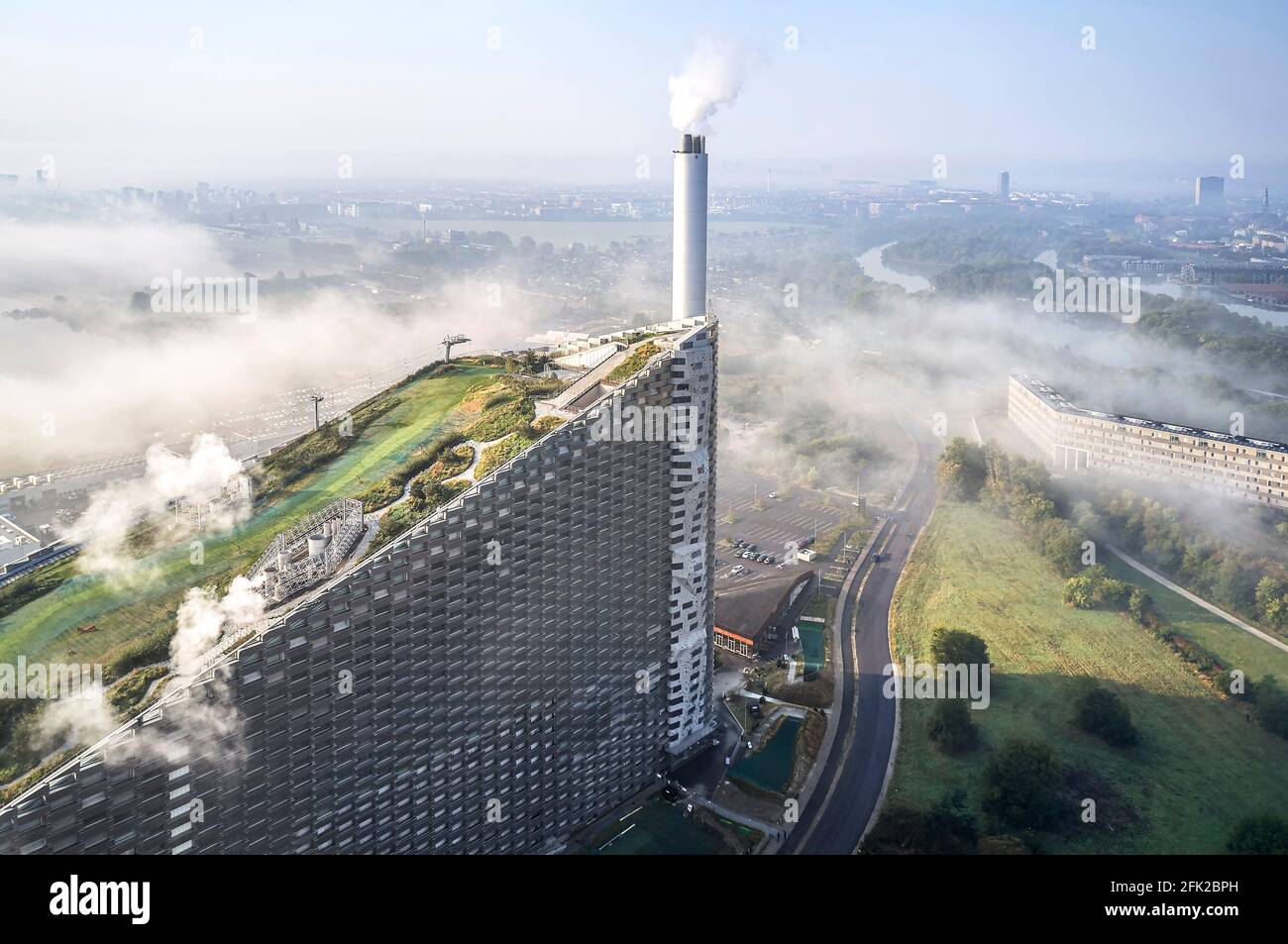 Vista a distanza con nuvole. Centrale elettrica di CoppenHill, Copenhagen, Danimarca. Architetto: BIG Bjarke Ingels Group, 2019. Foto Stock