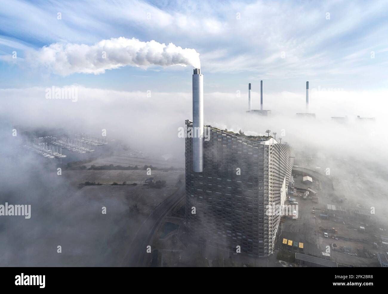 Vista a distanza con nuvole. Centrale elettrica di CoppenHill, Copenhagen, Danimarca. Architetto: BIG Bjarke Ingels Group, 2019. Foto Stock