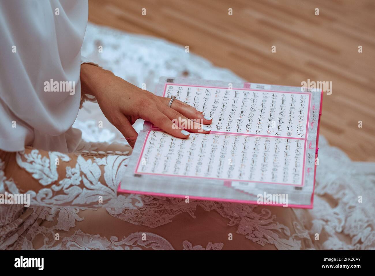 Primo piano di un giovane musulmano che legge il Corano, il sacro libro islamico Foto Stock