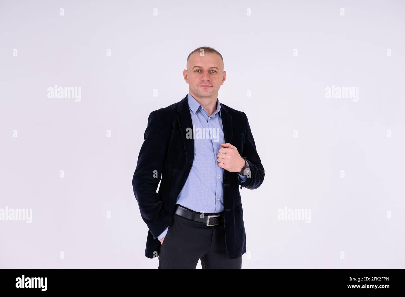 Uomo che indossa una camicia blu, pantaloni neri e una giacca blu su sfondo  bianco Foto stock - Alamy