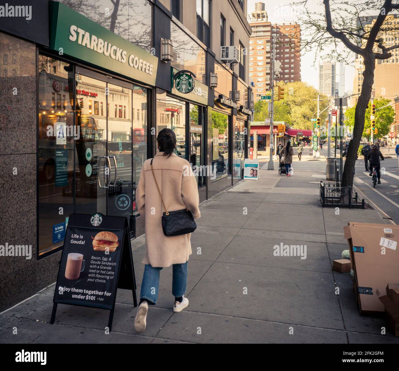 New York, Stati Uniti. 27 Apr 2021. Woman cammina davanti a uno Starbucks nel quartiere Chelsea di New York martedì 27 aprile 2021. (ÂPhoto di Richard B. Levine) Credit: Sipa USA/Alamy Live News Foto Stock