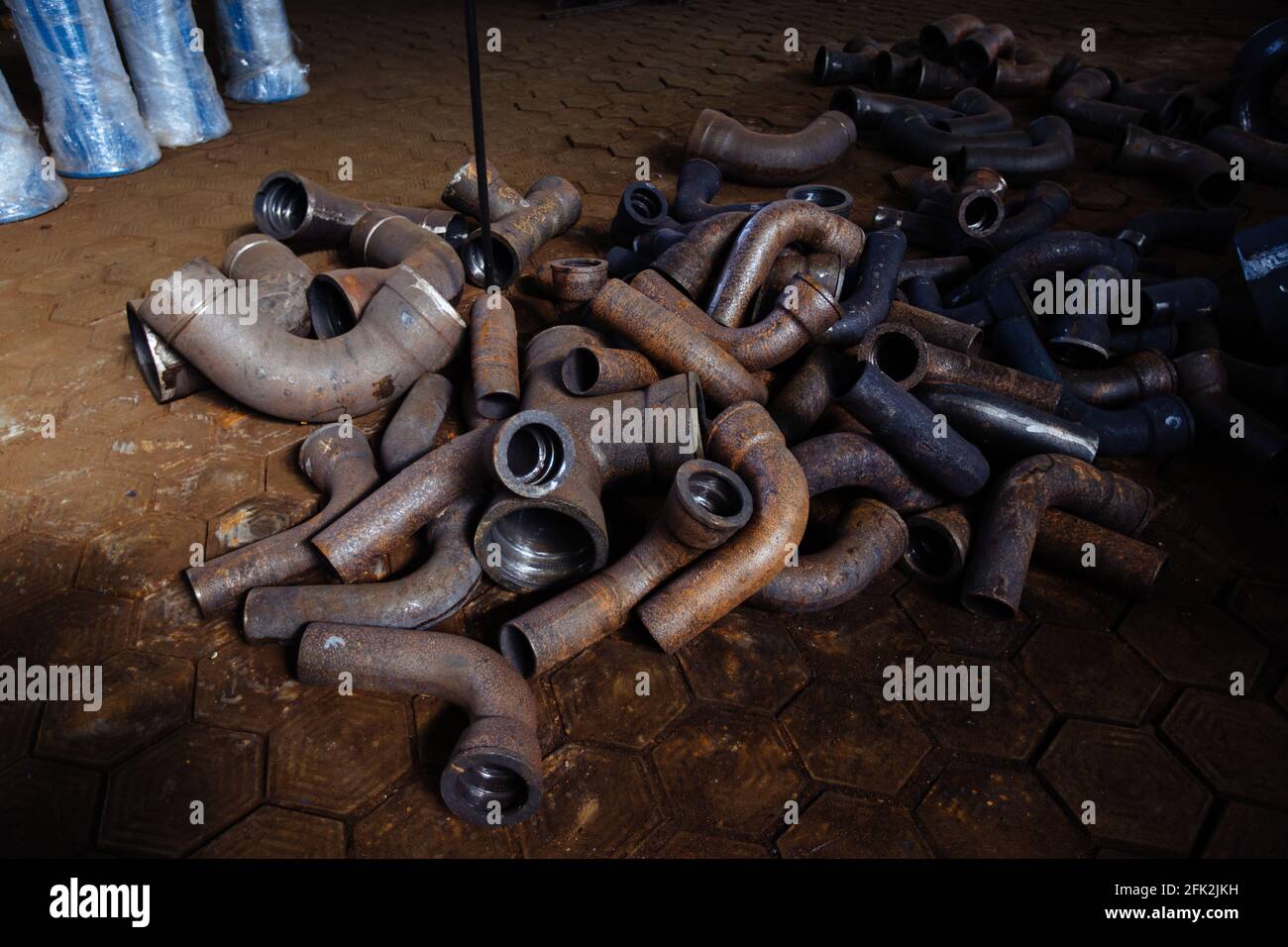 Parti di collegamento per tubi in metallo fuso in officina Foto Stock
