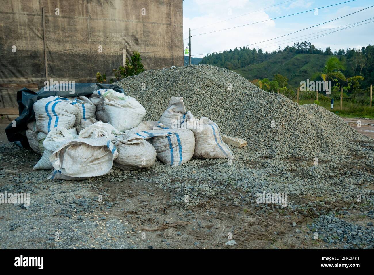 Detriti di costruzione scaricati vicino a una pila di pietre Foto Stock