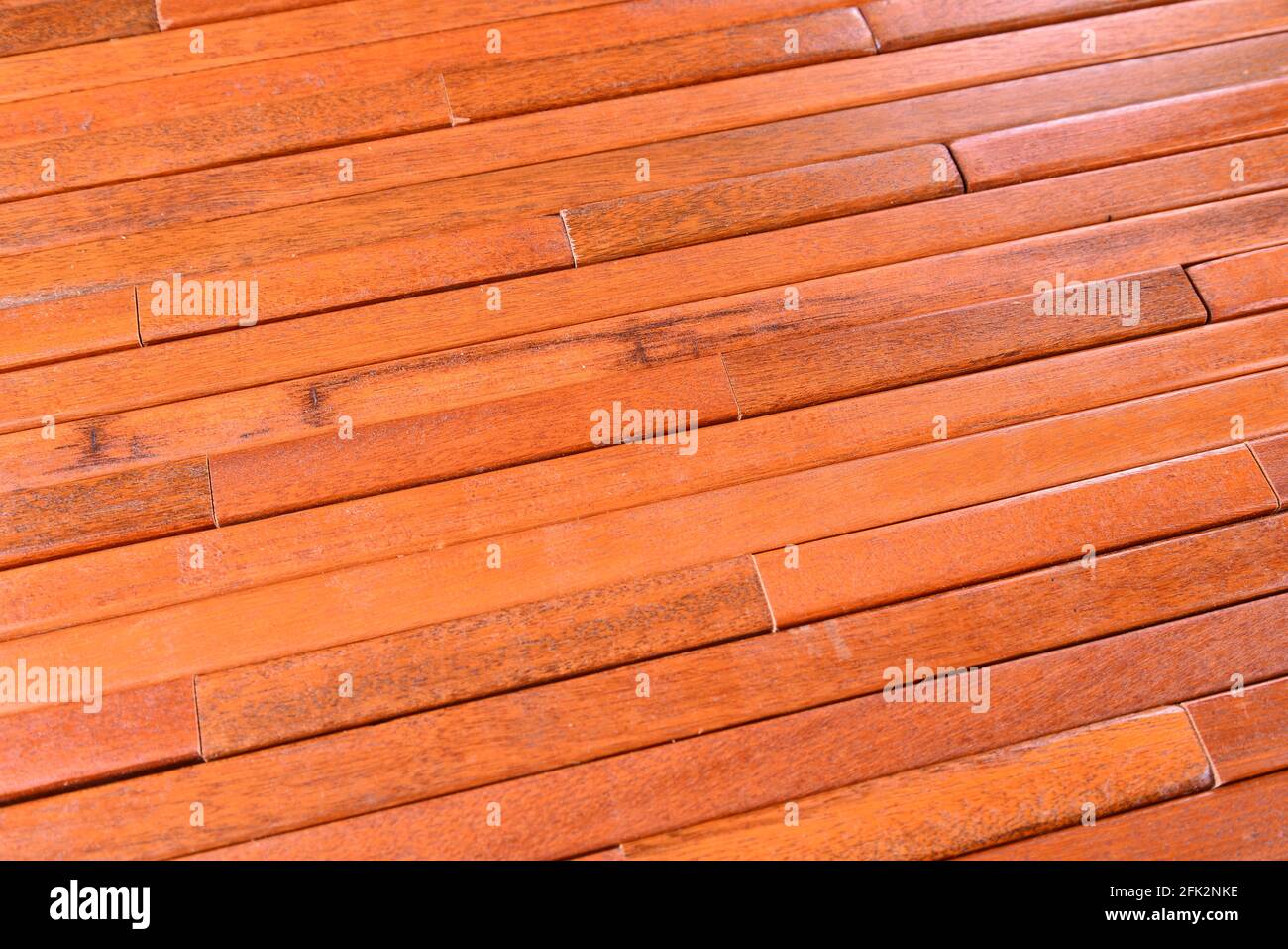 Pavimento con pannelli da 3/4 pollici posti sul lato per un forte supporto industriale. Le strisce di legno duro rosso marrone angolate sono affiancate. Foto Stock