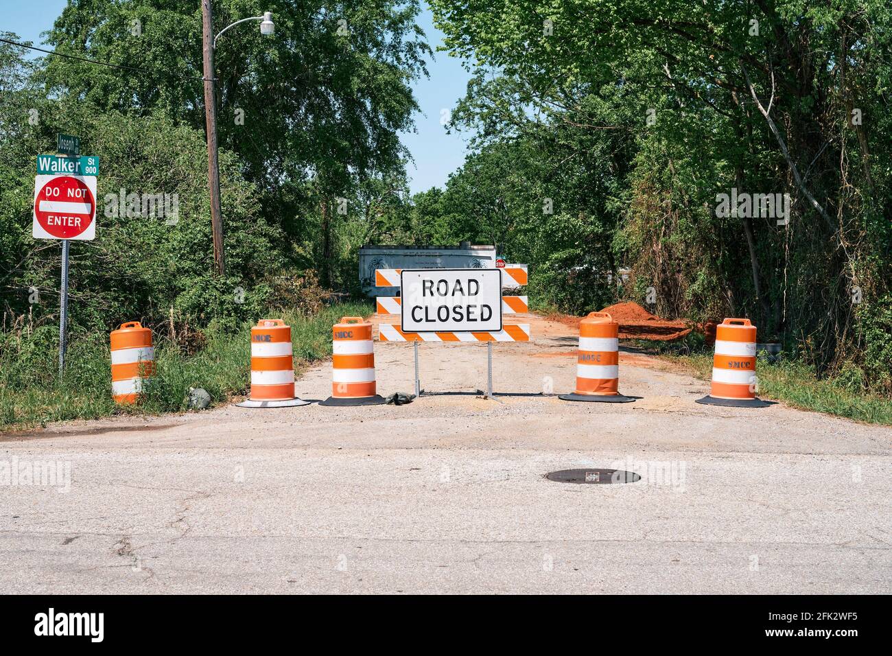 Strada chiusa segno e barriera più barili arancioni per chiudere una piccola strada a Montgomery Alabama, Stati Uniti. Foto Stock