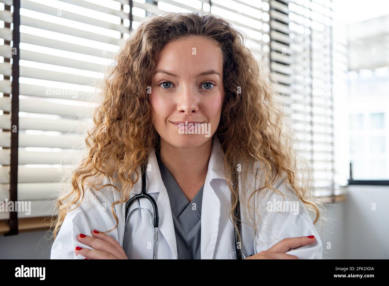 Sorridente medico femminile che guarda la fotocamera mentre fa la videochiamata in linea, concetti di servizio di consulazione medica domestica Foto Stock