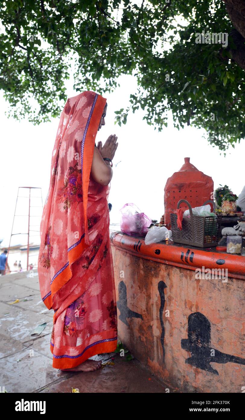 Una donna indiana pregando dal fiume Gange a Varanasi. Foto Stock