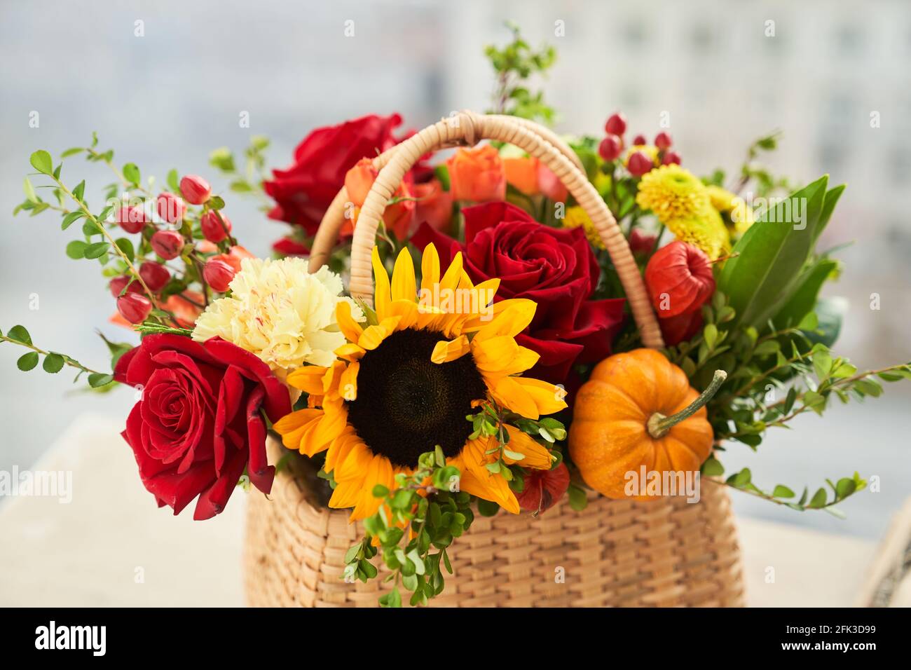 Fiori d'autunno misti, girasole, zucca, rosa, physalis nel cesto, bouquet è sul davanzale. Foto di alta qualità Foto Stock