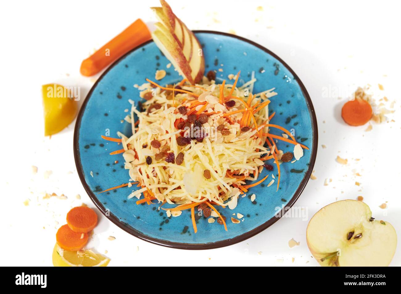Vista dall'alto della mela grattugiata con carote in un moderno bel piatto blu su sfondo bianco. Concetto di alimentazione adeguata senza zucchero e con frutta e verdura sane. Foto Stock