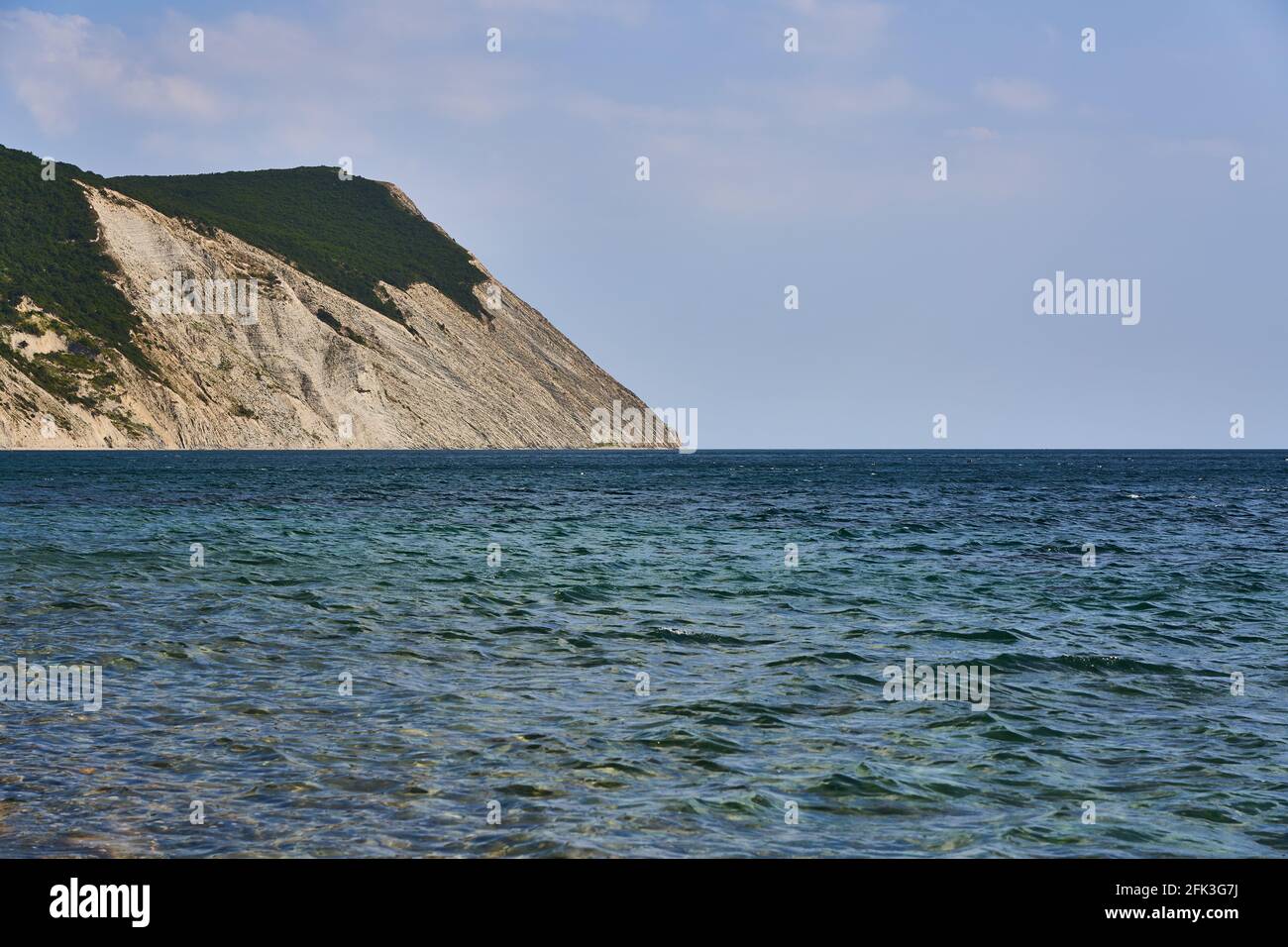 Vista panoramica della superficie del mare dalla costa. Sulla sinistra si trova una roccia. Mar Nero, Supseh, Anapa, regione di Krasnodar, Russia. Foto Stock