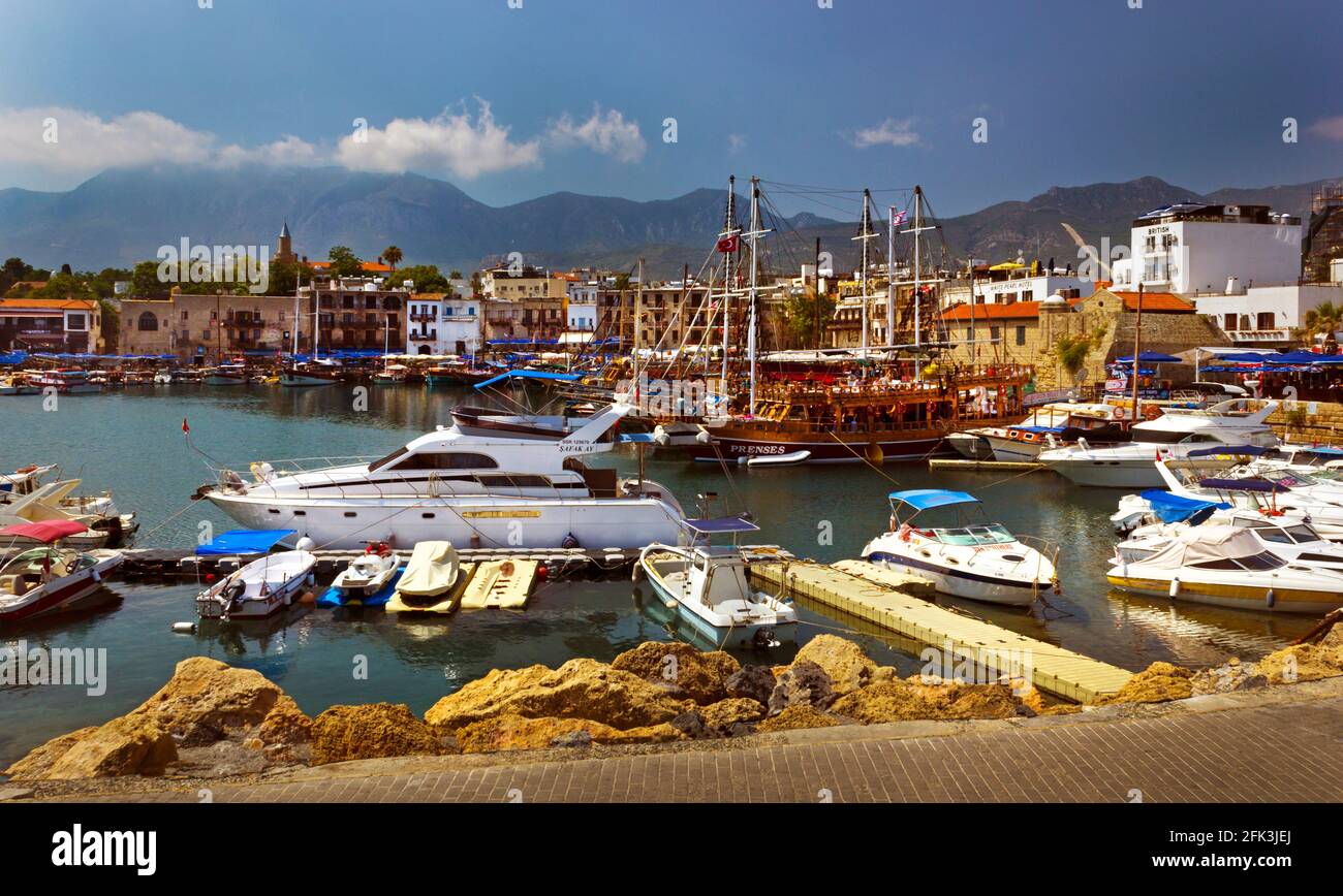 Porto di Girne Repubblica Turca di Cipro del Nord, Europa, con barche ed edifici con montagne e cielo spazio copia Foto Stock