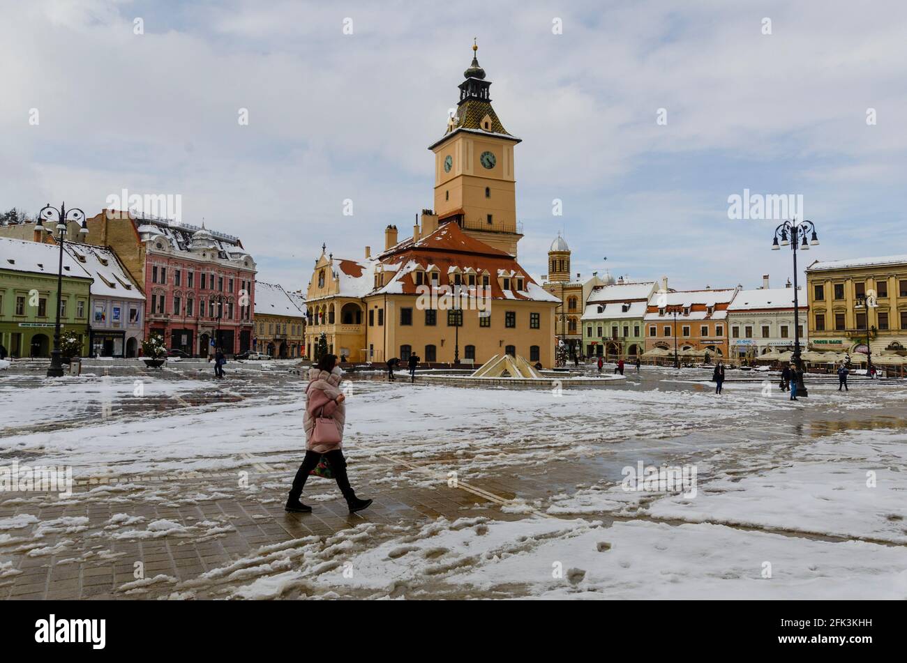 Neve di primavera nel centro storico di Brasov Romania. La famosa Casa Sfatului - conosciuta in inglese come la Casa del Consiglio - è prominente nel backgroun Foto Stock