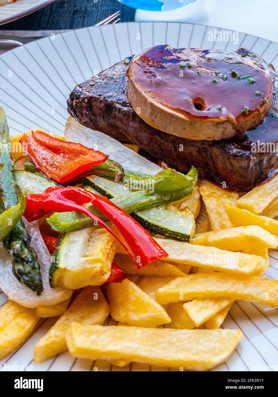 Bistecca con patatine fritte e foie con un po' di pepe Foto Stock