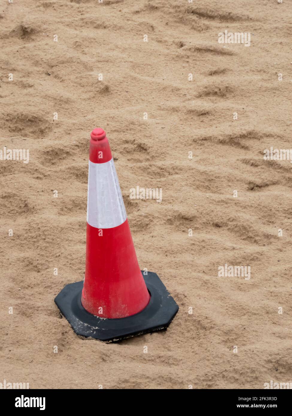 Primo piano del cono di avvertimento sulla sabbia di una spiaggia Foto Stock