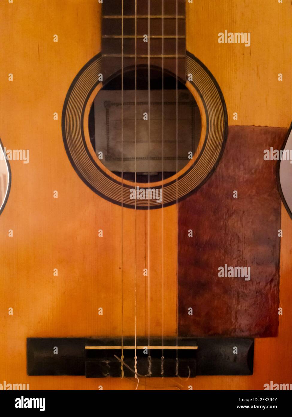 Dettaglio di una vecchia e deteriorata chitarra spagnola con un stringa mancante Foto Stock