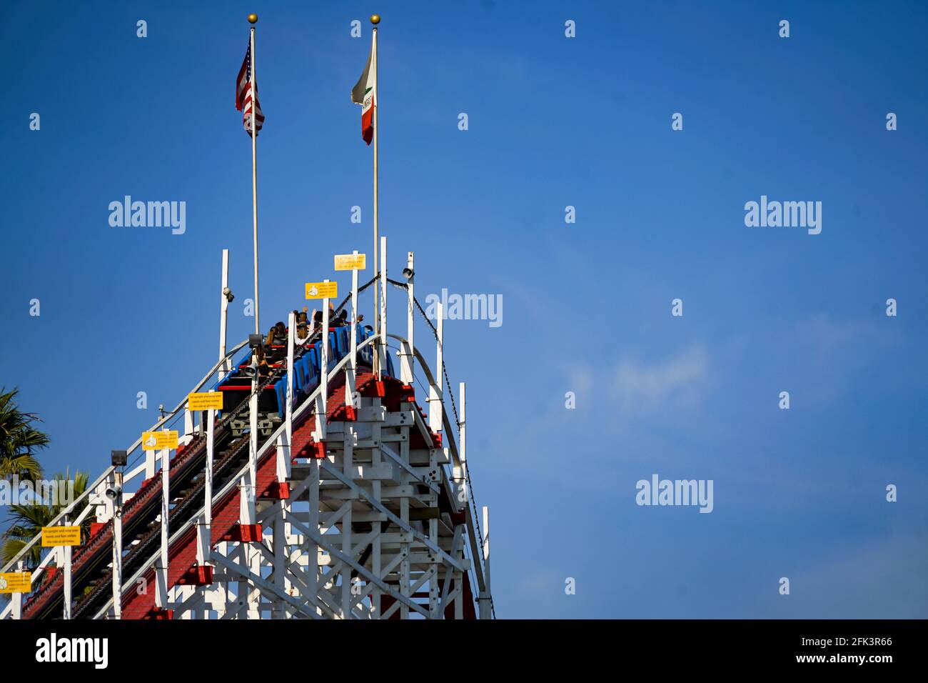 Le autovetture raggiungono il picco dell'unica montagna di montagne russe in legno ancora in funzione al mondo, il "Giant Dipper" a Santa Cruz Beach Bordwalk, California. Foto Stock