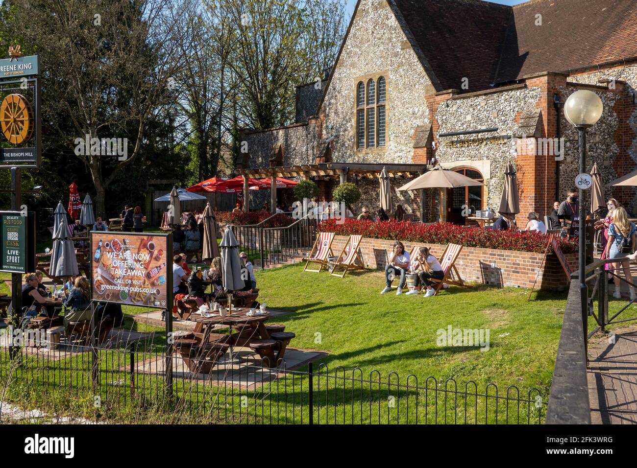 Salisbury, Wiltshire, Regno Unito. 2021. Il fiume Avon scorre davanti ai clienti che si accodano e mangiano fuori del pub Bishops Mill durante la chiusura di Covid. Foto Stock