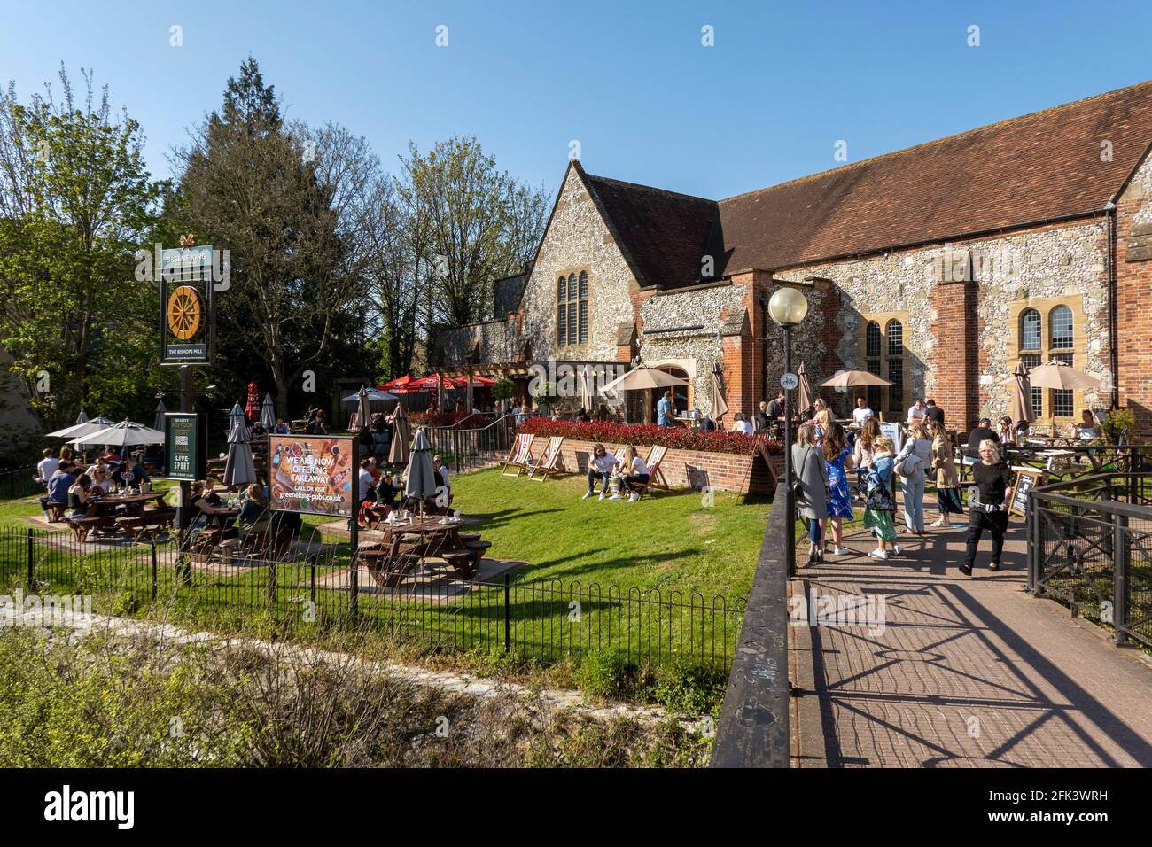 Salisbury, Wiltshire, Regno Unito. 2021. Il fiume Avon scorre davanti ai clienti che si accodano e mangiano fuori del pub Bishops Mill durante la chiusura di Covid. Foto Stock