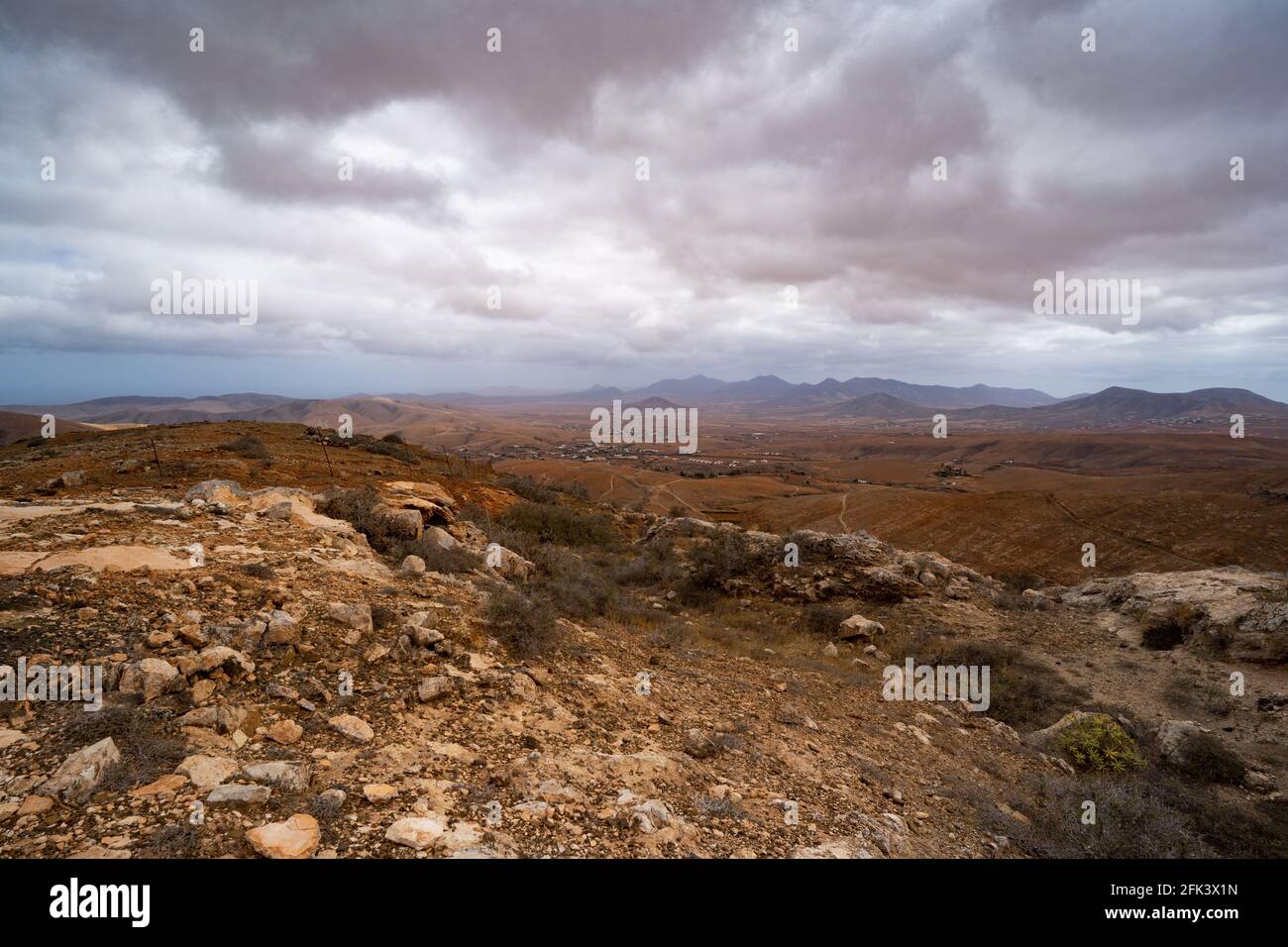 Solitario paesaggio desertico sotto le nubi basse pendenti Foto Stock