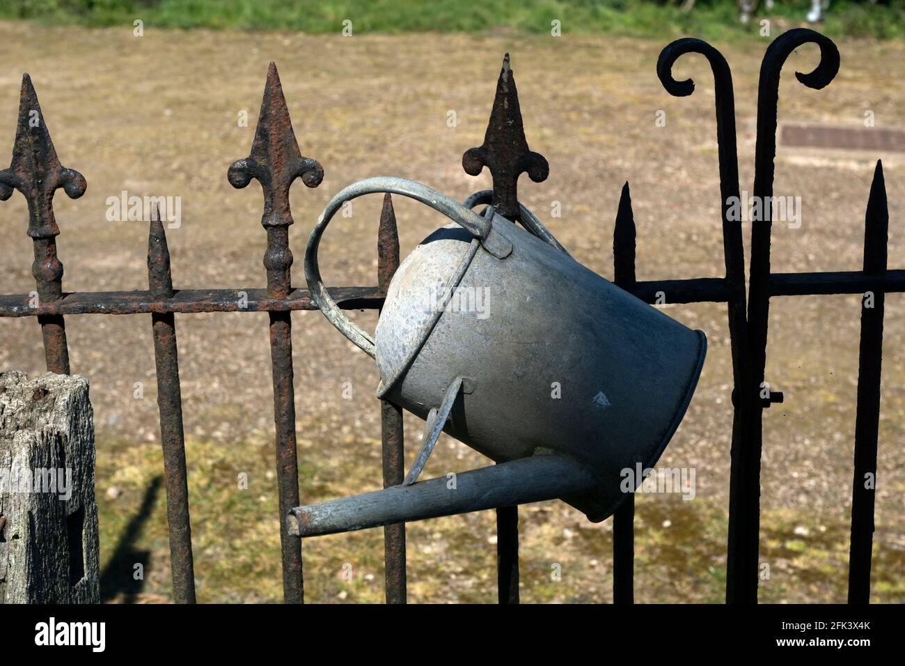 Un vecchio annaffiatoio di metallo, St. Peter`s Churchyard, Church Lawford, Warwickshire, Inghilterra, REGNO UNITO Foto Stock