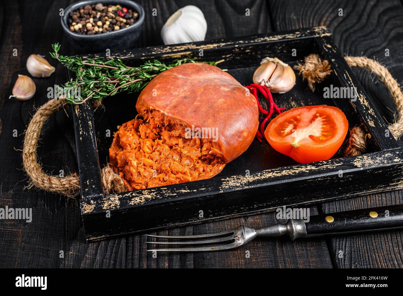 Mallorcan Sobrassada salumi di carne di maiale in un vassoio di legno sfondo di legno nero. Vista dall'alto Foto Stock