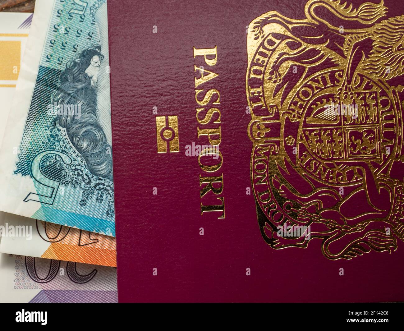 Primo piano del passaporto britannico dell'isola di Man con carta denaro all'interno Foto Stock