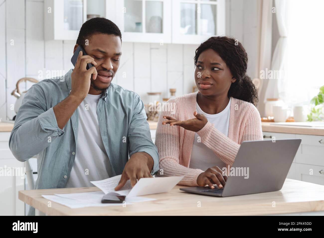 Sconvolgere i coniugi africani che hanno problemi finanziari, il controllo delle carte ipotecarie in cucina Foto Stock