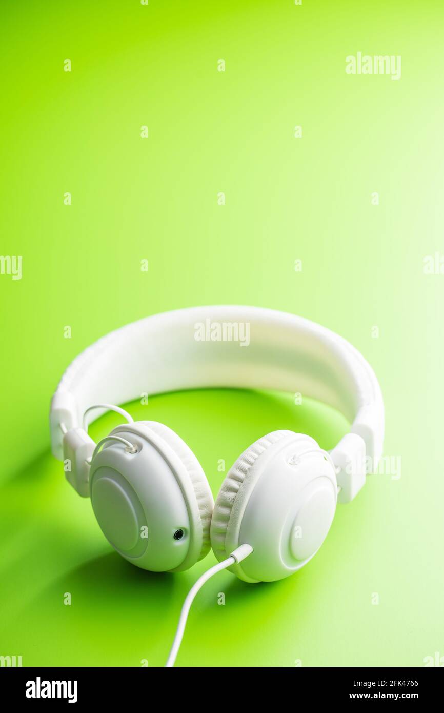 Cuffie stereo bianche cablate su sfondo verde. Foto Stock
