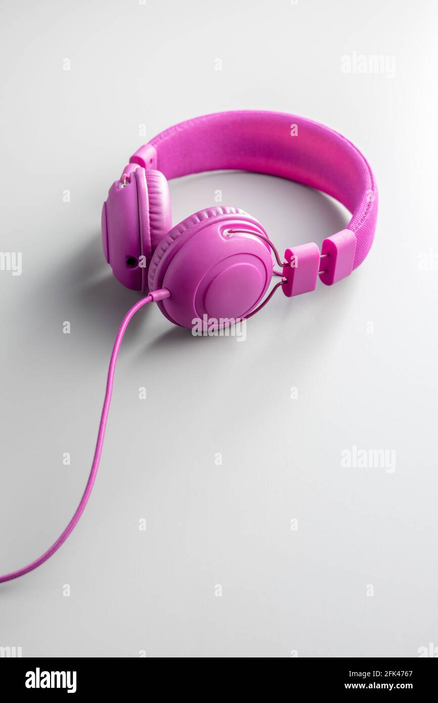 Cuffie stereo con fili rosa su sfondo grigio. Foto Stock